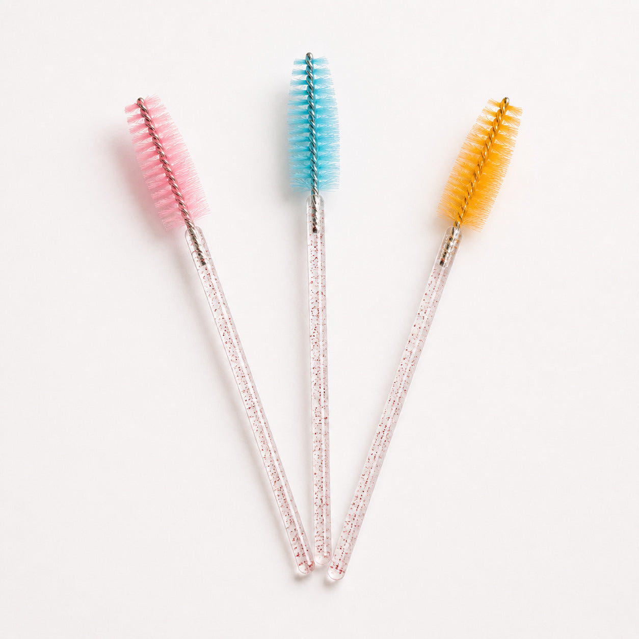 Pink, blue and yellow disposable eyelash spoolie brush detail